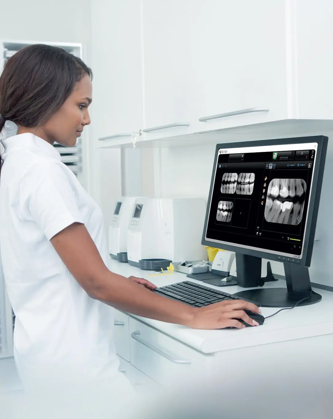 Dental nurse viewing intraoral X-rays from a Carestream CS 7600 on a workstation